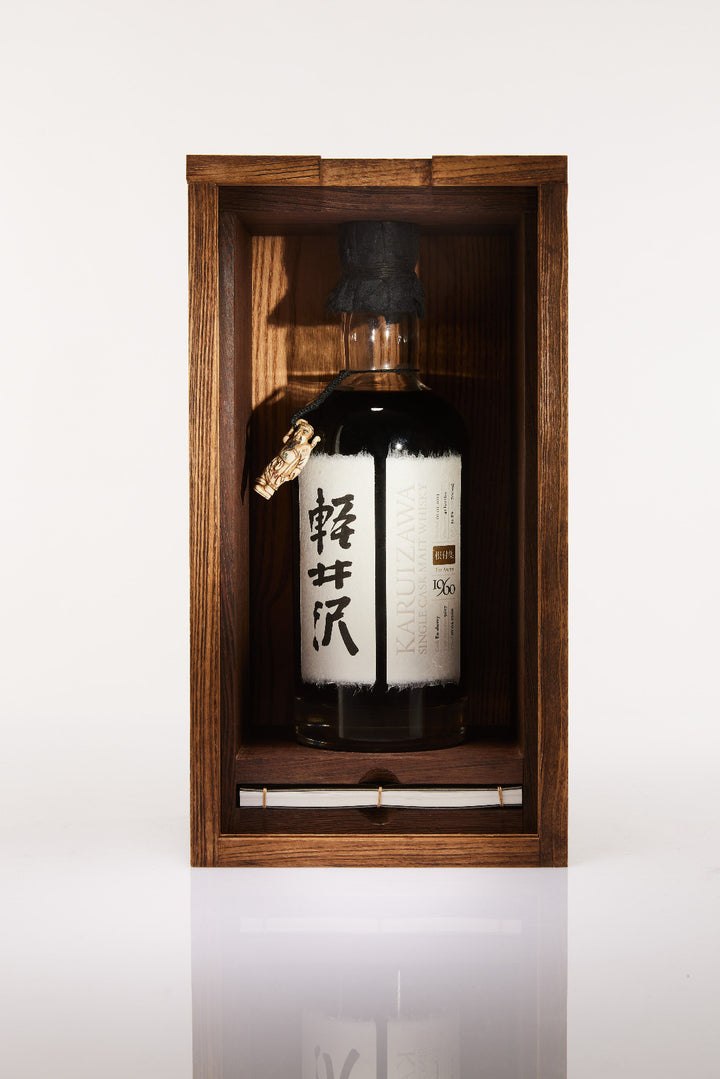 Bottle of Japanese whisky in a wooden display case on a white background